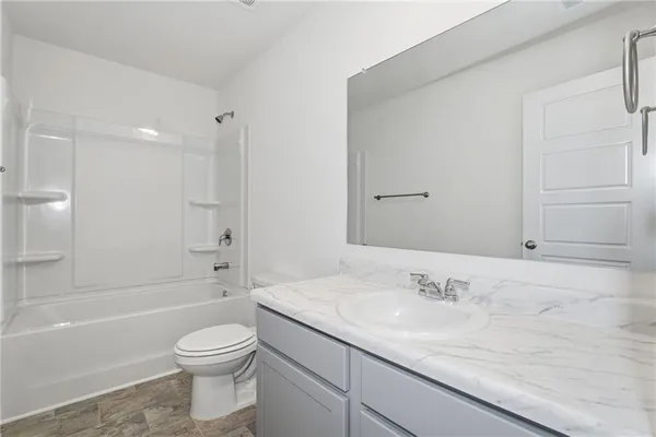 a bathroom with a granite countertop sink a toilet and bathtub