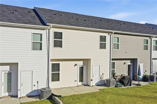 a backyard of a house with yard table and chairs