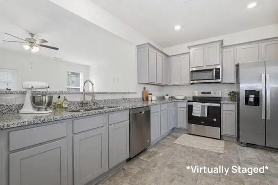 a kitchen with granite countertop a sink stainless steel appliances and white cabinets