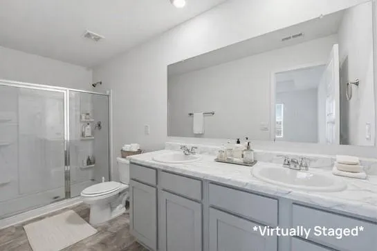 a bathroom with a sink a toilet and shower
