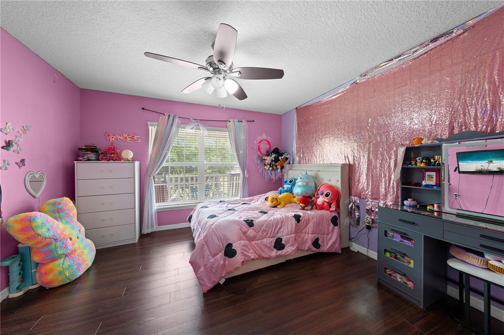 1965 Mustang Court St. Cloud, FL 34771 - Photo 20 of 33 a bedroom with a bed and wooden floor