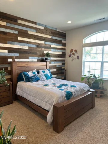a bed sitting in a bedroom next to a window
