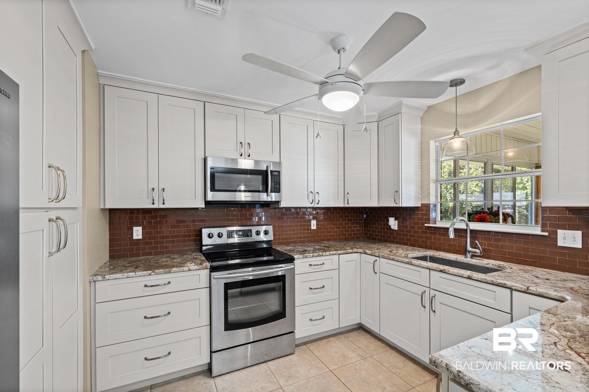 2881 Eslava Circle Lillian, AL 36549 - Photo 11 of 58 Kitchen featuring stainless steel appliances, light stone countertops, and white cabinets