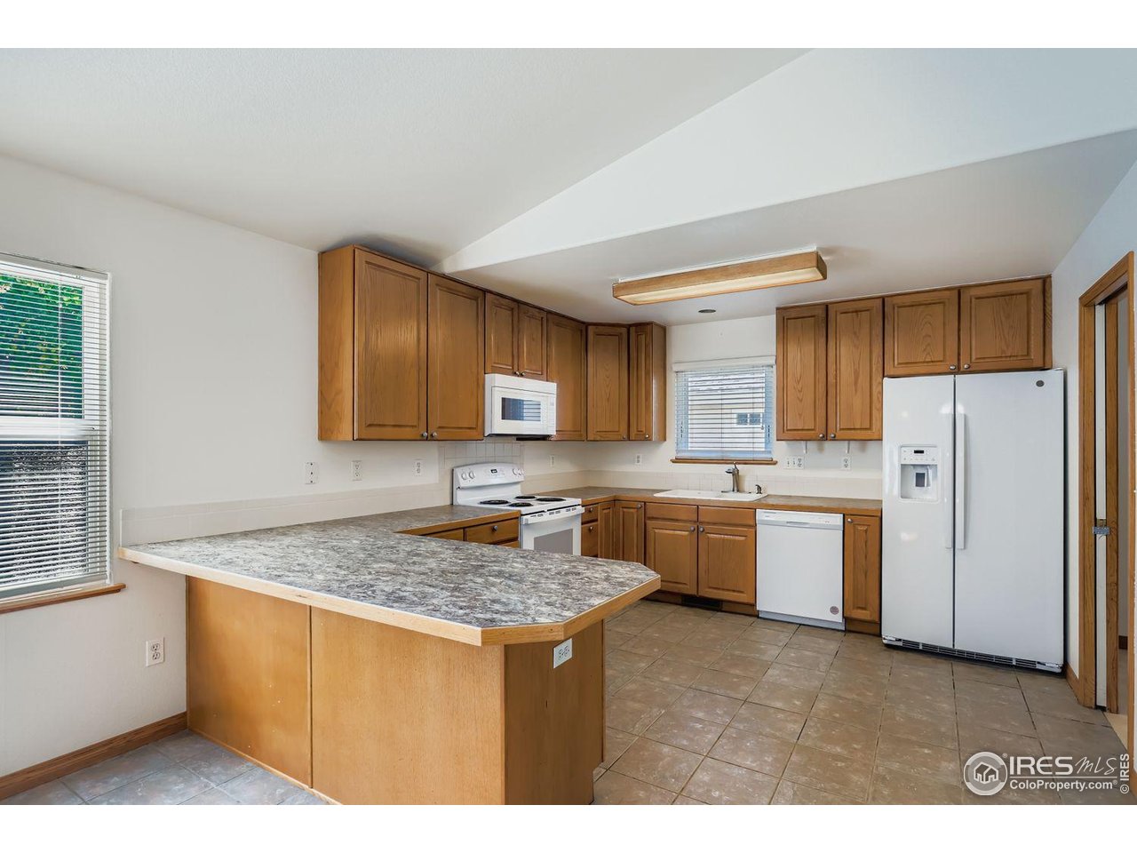 310 Bein Street Berthoud, CO 80513 - Photo 9 of 31 a kitchen with a refrigerator and a sink
