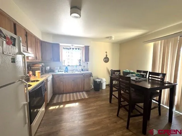 a kitchen with stainless steel appliances granite countertop table chairs sink and cabinets