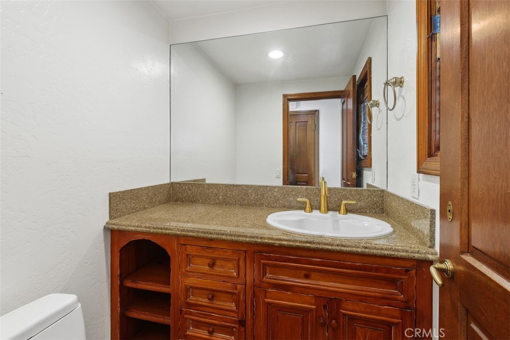 38285 Oaktree Loop Murrieta, CA 92562 - Photo 14 of 39 a bathroom with a granite countertop sink and a mirror
