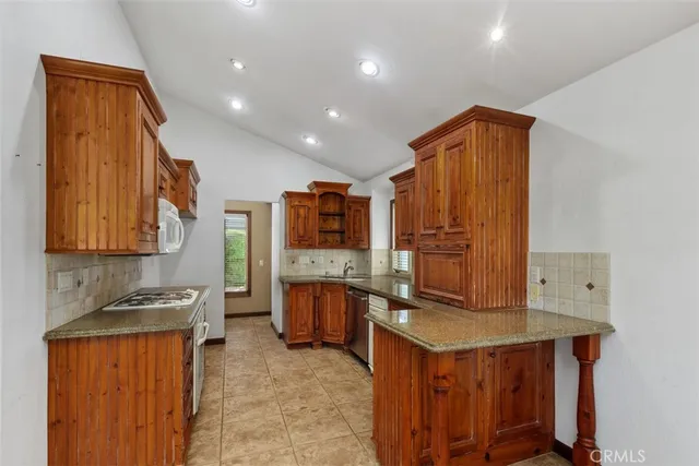 a kitchen with stainless steel appliances granite countertop a stove a sink and a microwave