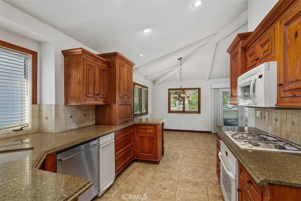 38285 Oaktree Loop Murrieta, CA 92562 - Photo 18 of 39 a kitchen with stainless steel appliances granite countertop a stove a sink and a microwave