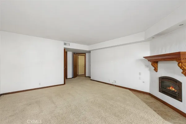 a view of an empty room with a fireplace and a window