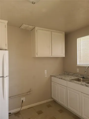 a bathroom with a granite countertop sink and cabinets