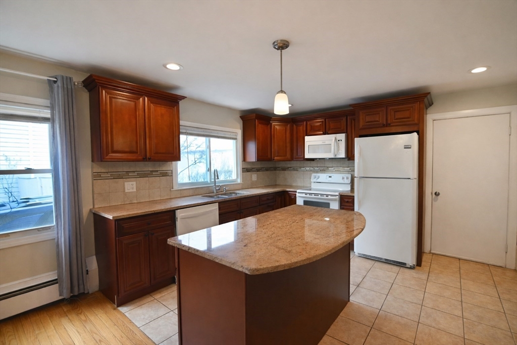 a kitchen with stainless steel appliances granite countertop a sink a refrigerator and a stove