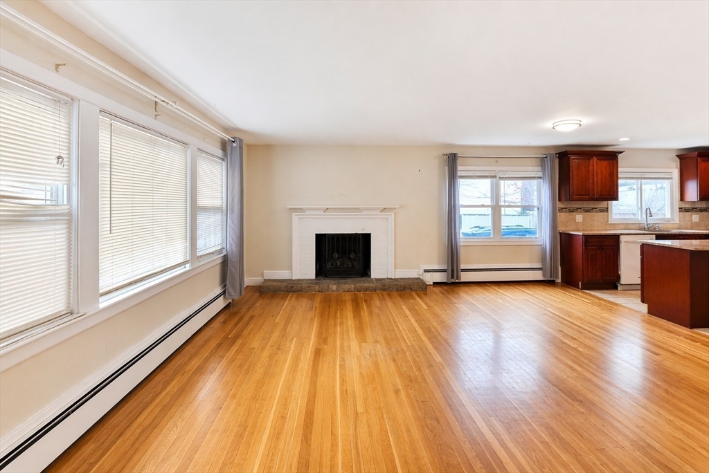 44-42 Farquhar Road, Unit 1 Newton, MA 02460 - Photo 3 of 11 a view of empty room with wooden floor and fireplace