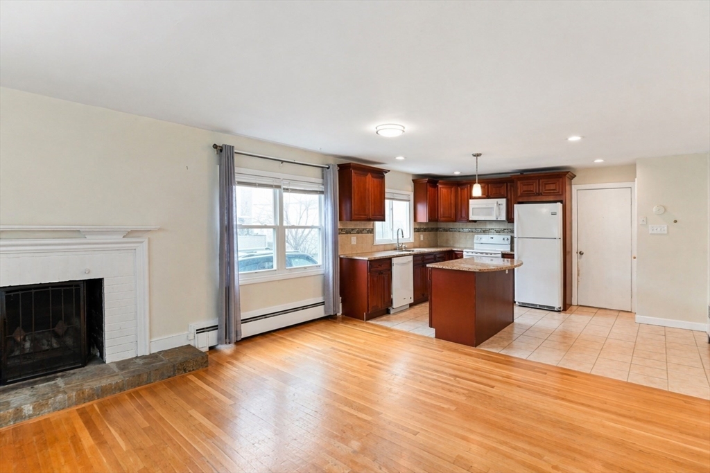 44-42 Farquhar Road, Unit 1 Newton, MA 02460 - Photo 4 of 11 a kitchen with stainless steel appliances kitchen island granite countertop a stove top oven sink and cabinets