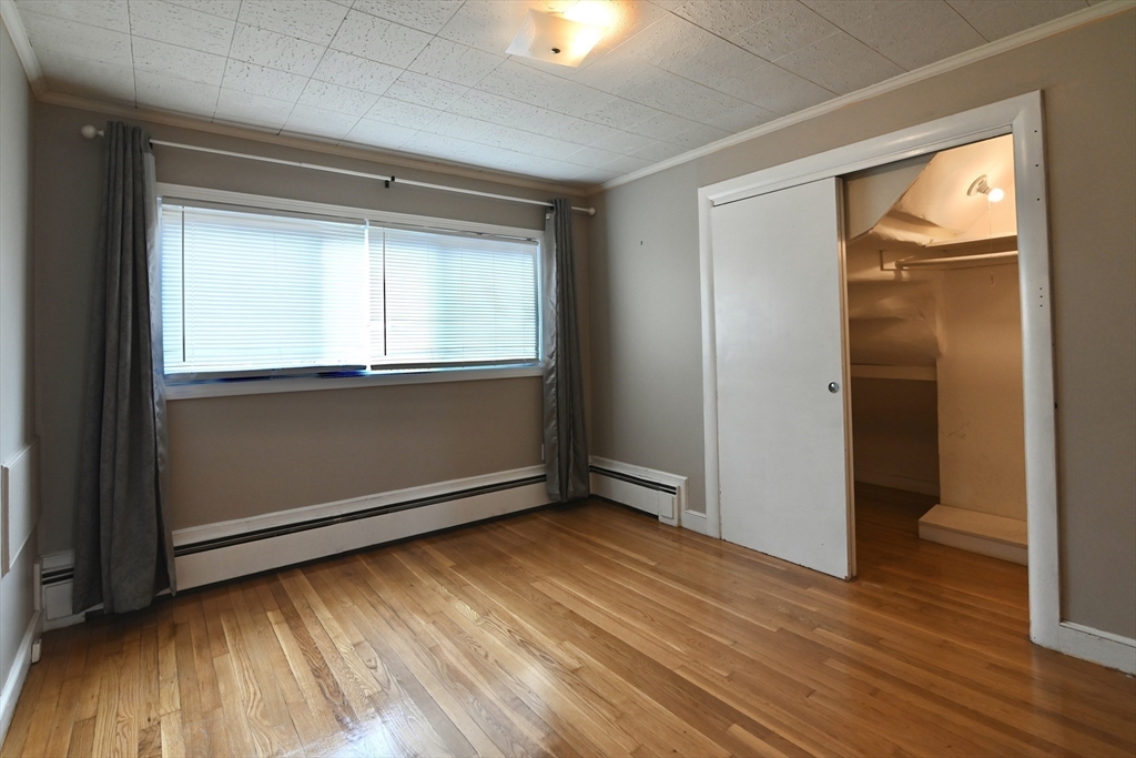 44-42 Farquhar Road, Unit 1 Newton, MA 02460 - Photo 6 of 11 an empty room with wooden floor and a window