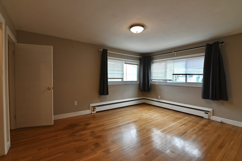 44-42 Farquhar Road, Unit 1 Newton, MA 02460 - Photo 8 of 11 an empty room with wooden floor and windows