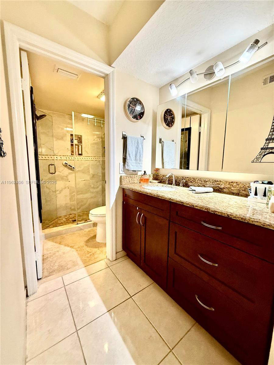 351 Club Circle, Unit 102 Boca Raton, FL 33487 - Photo 25 of 34 a spacious bathroom with a granite countertop sink mirror and a