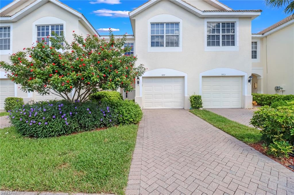 a front view of a house with a yard and potted plants