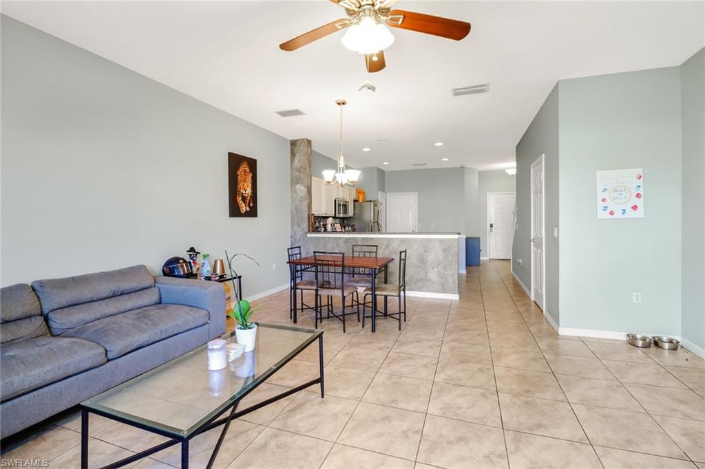977 Hampton Circle, Unit 118 Naples, FL 34105 - Photo 12 of 24 a living room with furniture and a dining table with kitchen view