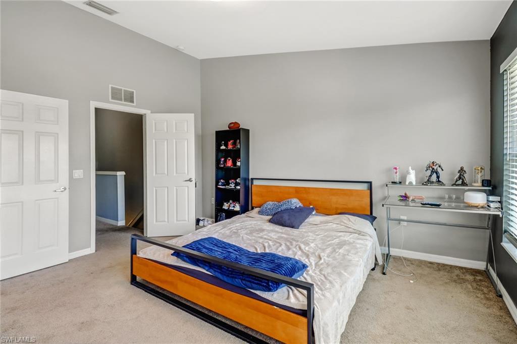 977 Hampton Circle, Unit 118 Naples, FL 34105 - Photo 15 of 24 a bedroom with a bed and dresser