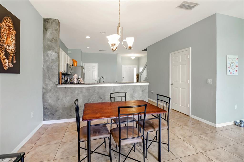 977 Hampton Circle, Unit 118 Naples, FL 34105 - Photo 9 of 24 a view of a dining room with furniture and chandelier