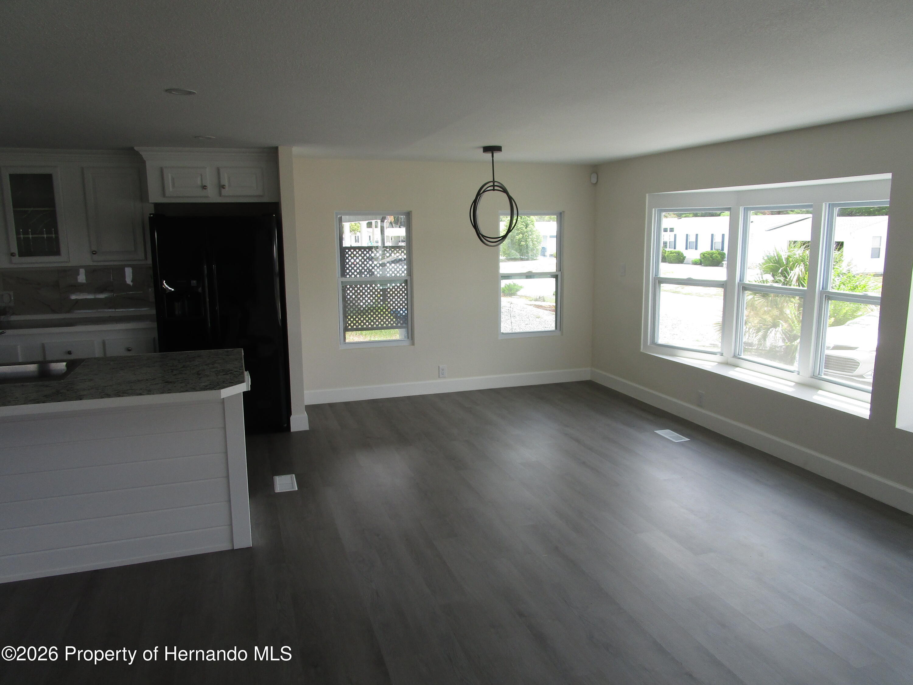 14790 Rialto Avenue, Unit 3 Brooksville, FL 34613 - Photo 13 of 15 an empty room with wooden floor and windows