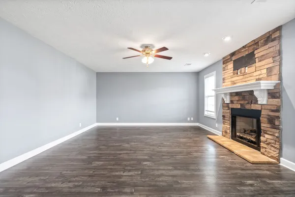 a view of empty room with a fireplace and window