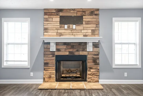 a living room with a fireplace and windows