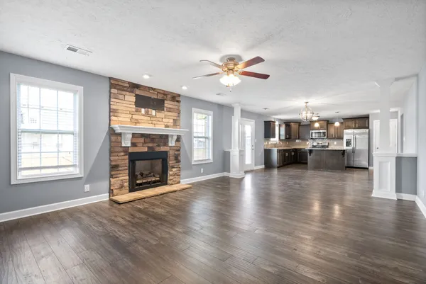 an empty room with fireplace wooden floor and a window