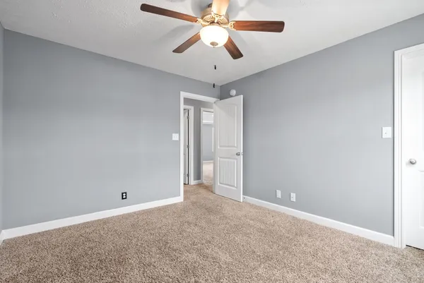 an empty room with closet and a chandelier fan