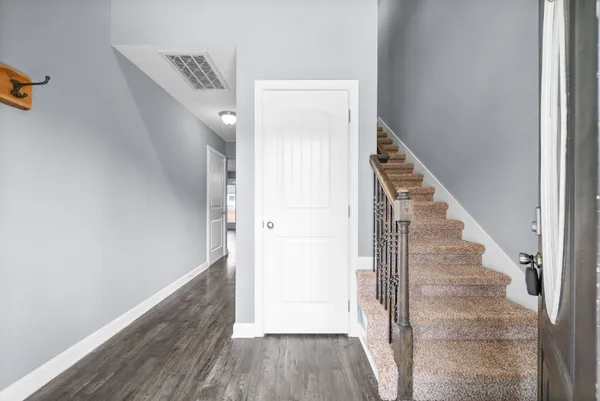 a view of a hallway with wooden floor and staircase