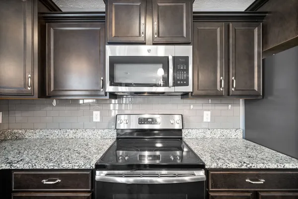 a kitchen with granite countertop stainless steel appliances and cabinets