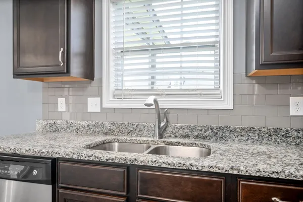 a kitchen with granite countertop a sink and a window