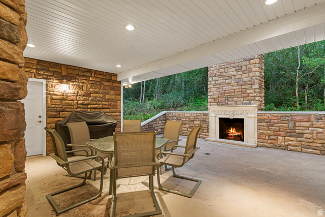 1133 Paris Canyon Road Paris, ID 83261 - Photo 49 of 74 Covered outdoor patio featuring extensive stone wall cladding, a built-in stone fireplace with an ornate mantel, and recessed ceiling lighting