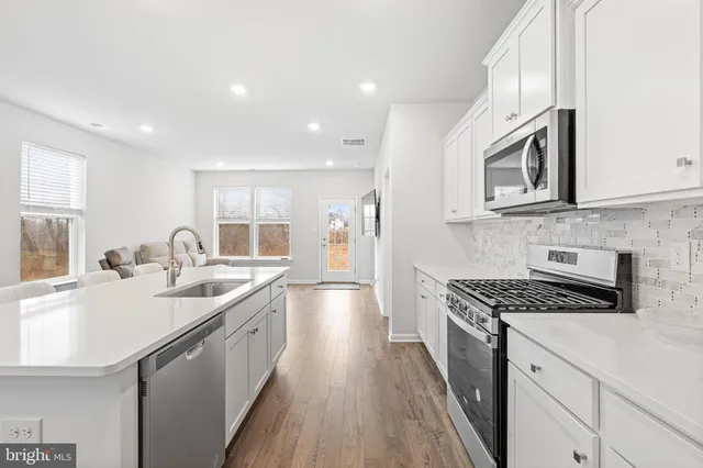a kitchen with granite countertop a sink stove and cabinets
