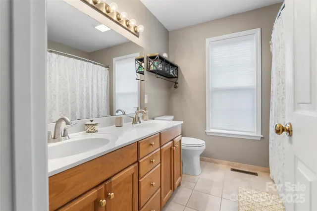 a en suite bathroom with a sink double vanity and a mirror