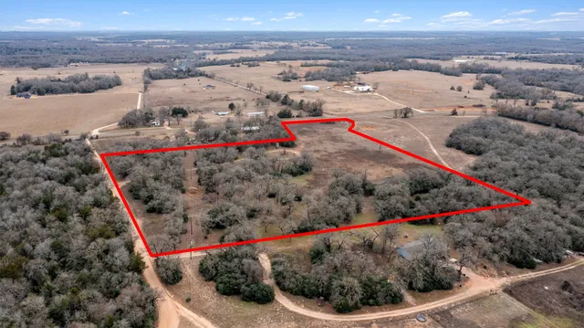 a view of a yard with wooden fence