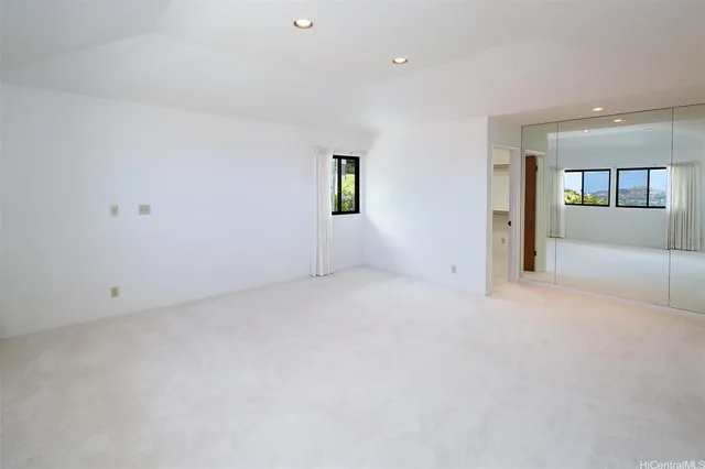 an empty room with a bathroom and mirror