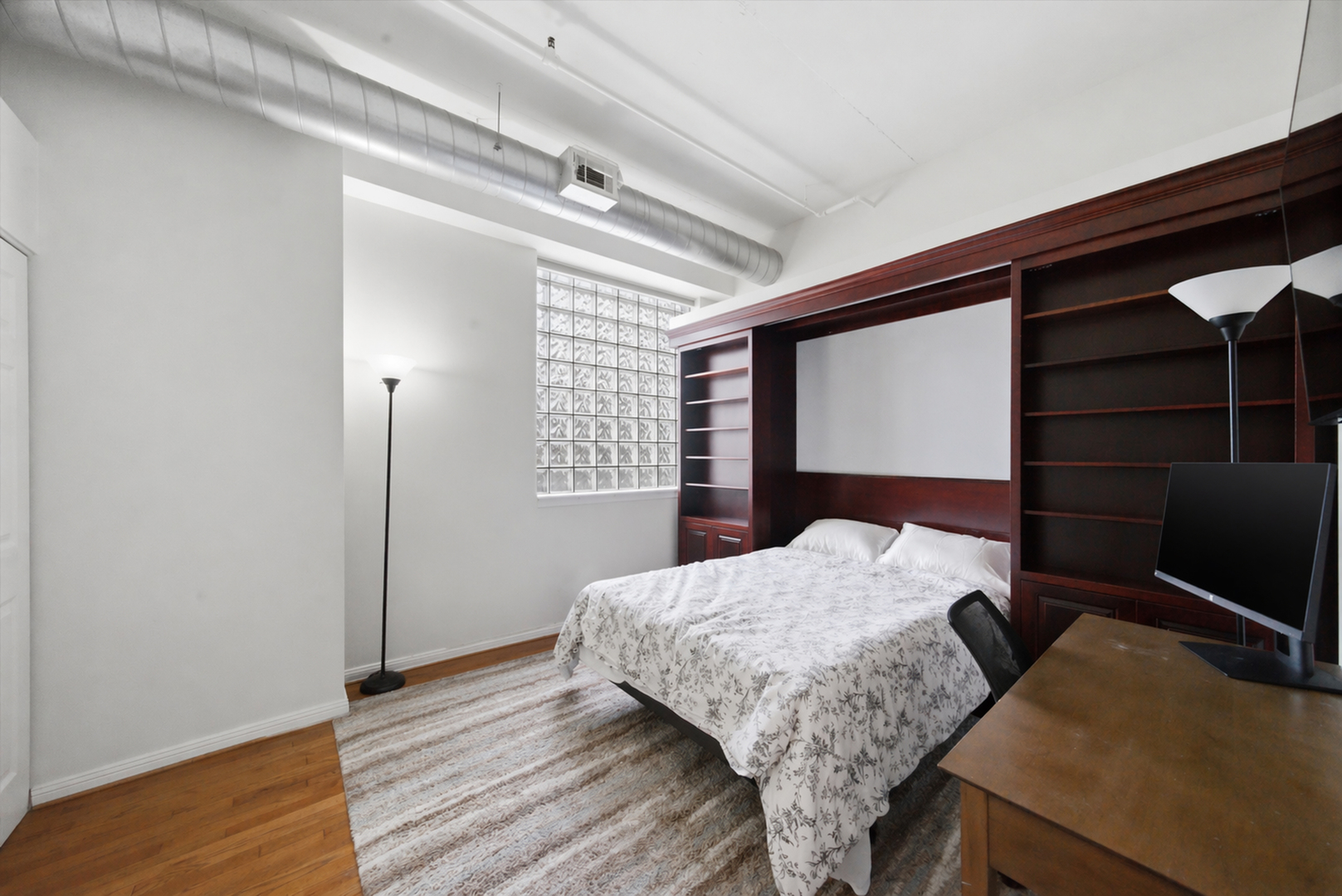 950 West Monroe Street, Unit 401 Chicago, IL 60607 - Photo 19 of 27 a bedroom with a bed and a flat tv screen on dresser