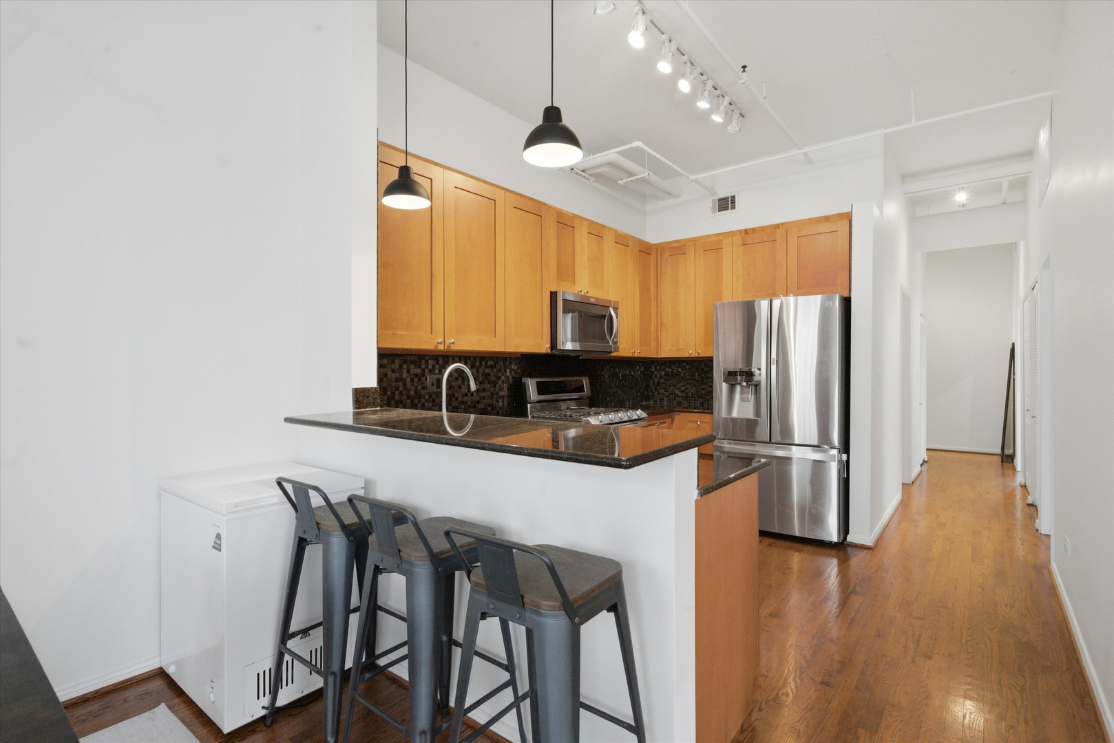 950 West Monroe Street, Unit 401 Chicago, IL 60607 - Photo 3 of 27 a kitchen with stainless steel appliances granite countertop a refrigerator a stove a sink a dining table and chairs with wooden floor