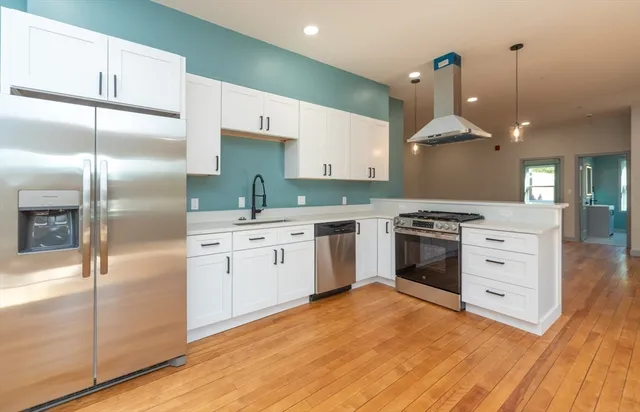 a kitchen with white cabinets and stainless steel appliances