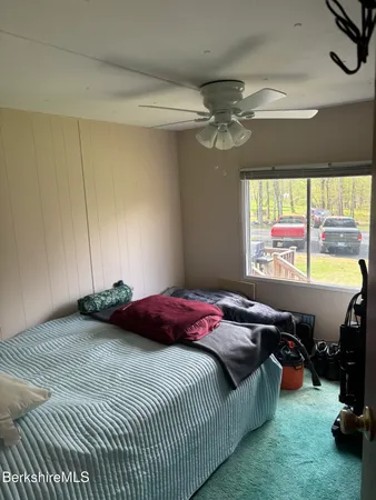 a bedroom with a bed and a large window