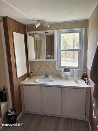 a bathroom with a granite countertop sink toilet and mirror
