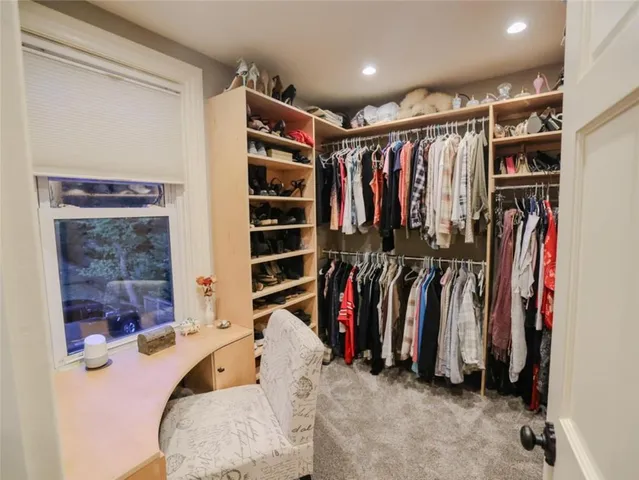 a view of walk in closet with clothes