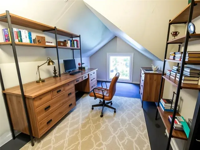 a view of a workspace with furniture and a window