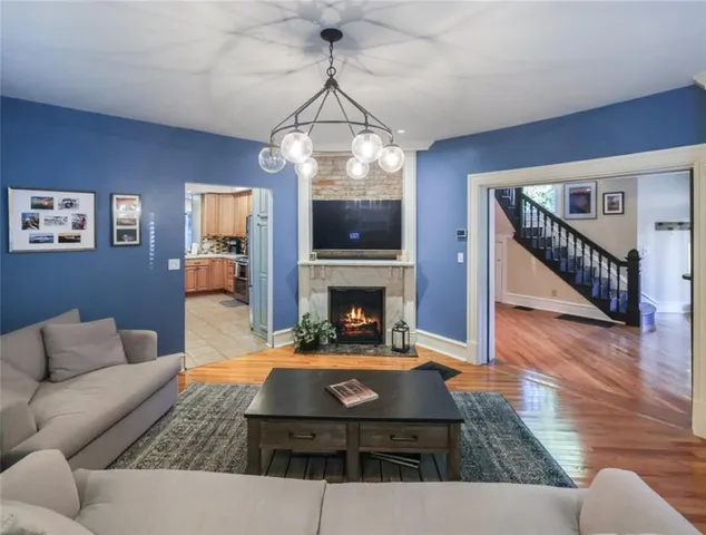 a living room with furniture a fireplace and a chandelier