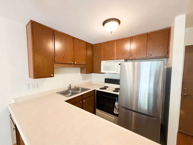 a kitchen with granite countertop a refrigerator sink and stove