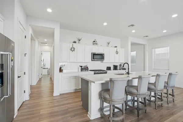 a large white kitchen with stainless steel appliances