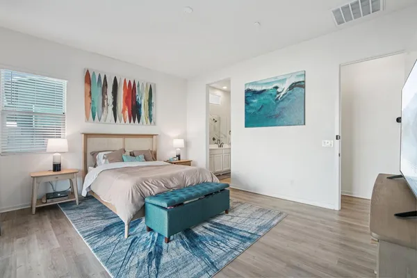 a bedroom with a bed and a painting on the wall