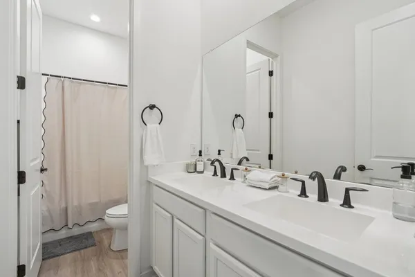 a bathroom with a double vanity sink toilet and shower