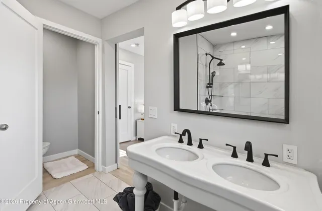 a bathroom with a sink and a mirror with toilet